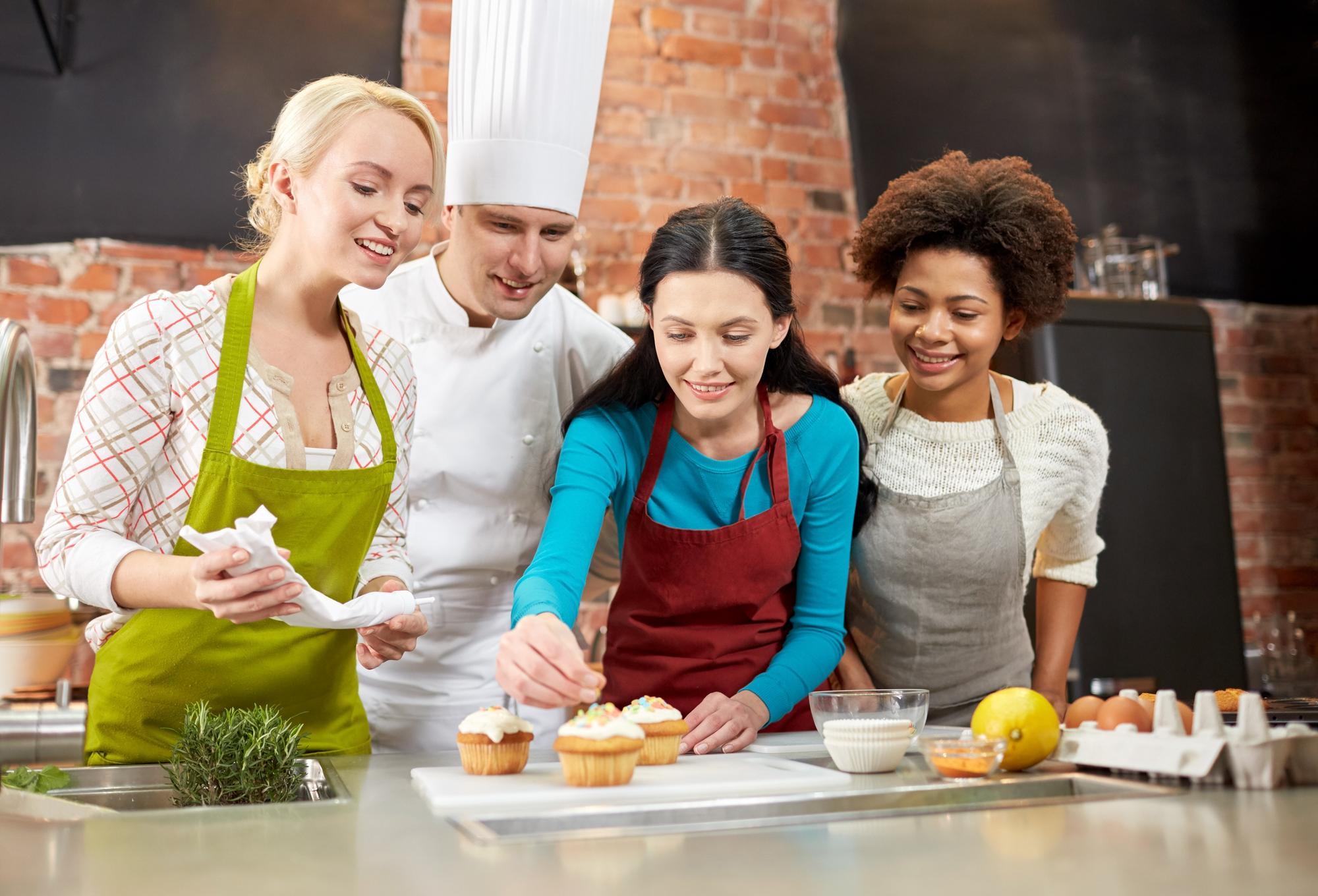 Students smiling in a bright kitchen workshop